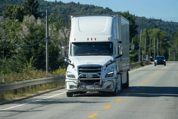 Kanada, 14 Ağustos 2025: Kırsal yolda orman arka planında görünen beyaz kamyonet