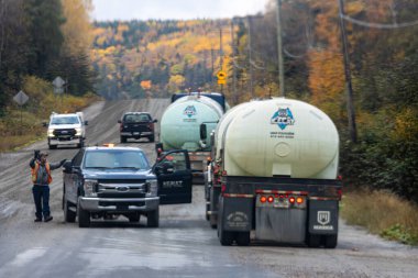 Kanada, 08 Ekim 2025: Sonbahar orman bakım operasyonu sırasında kırsal yolda toz kontrol kamyonları