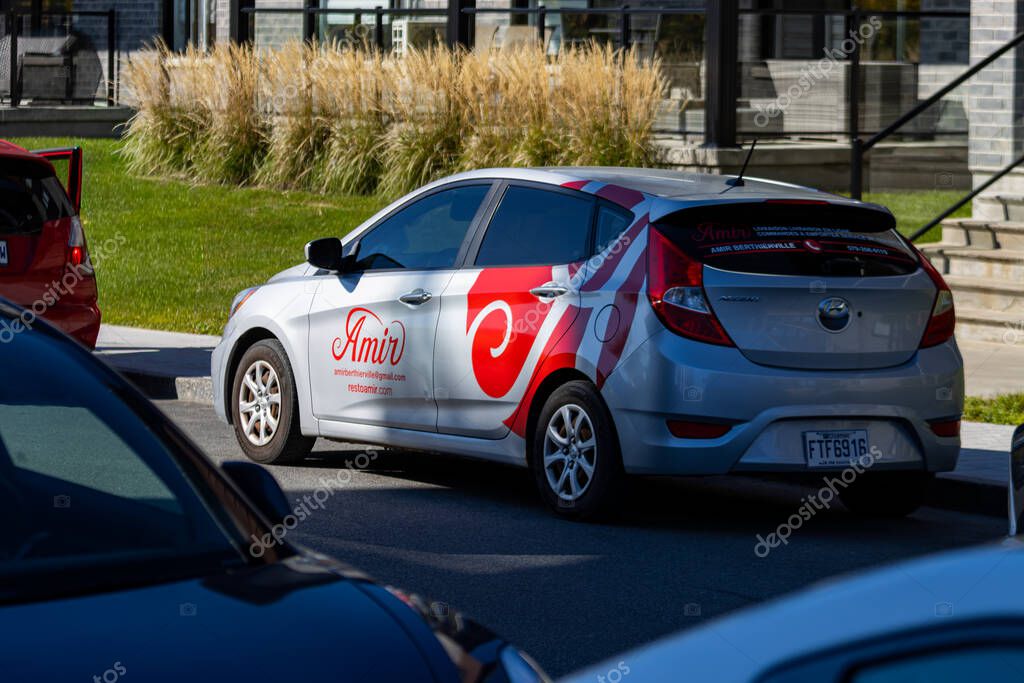 Canada, 11 October 2025 : Restaurant delivery car parked beside another vehicle in urban area