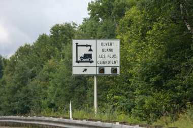 Quebec, Kanada, 20 Temmuz 2025: Yeşil orman geçmişi olan Fransız yol tabelası