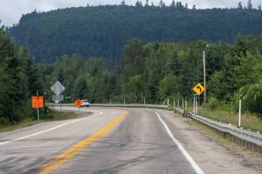 Kanada, 20 Temmuz 2025: Dağ yolu güvenlik işaretleriyle çevrili, virajlı, ormanlarla çevrili
