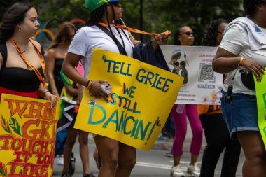 Quebec, Kanada, 05 Temmuz 2025: İnsanlar renkli protesto ve kutlama işaretleri taşıyarak şehir sokaklarında yürüyor