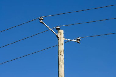 Kanada, 16 Eylül 2025: Kablolu ahşap elektrik direği mavi gökyüzü ve sabah güneşi