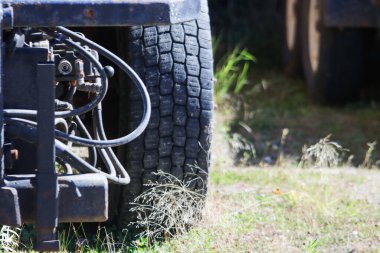 Kanada, 27 Eylül 2025: Çimenli zeminde güneş ışığında hidrolik hortumlu kamyon lastiği