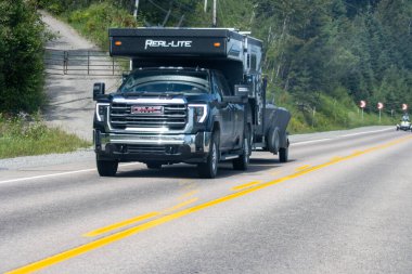 Kanada, 09 Ağustos 2025: Büyük siyah GMC kamyon çekicisi ve otoyol boyunca tekne