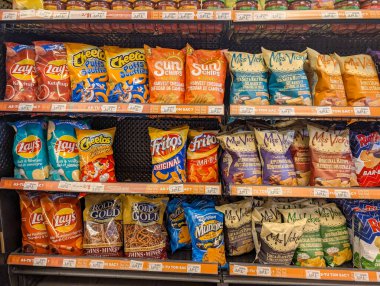Kanada, 08 Kasım 2025: Süpermarket raflarında sergilenen renkli patates cipsi ve abur cuburlar