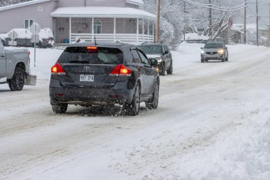 Kanada, 11 Kasım 2025: Arabalar kış fırtınası sırasında karlı yerleşim caddelerinde dikkatli bir şekilde sürüyorlar
