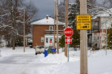 Kanada, 12 Kasım 2025: Fransız dur levhası ve güvenlik uyarısı ile kış mahallesi sahnesi
