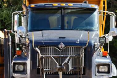 Kanada, 27 Eylül 2025: Yıpranmış siyah ve sarı dış görünüşlü engebeli çöp kamyonu