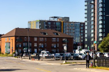 Kanada, 11 Ekim 2025: Otoparkı, yayaları, eski ve modern binaları olan güneşli kentsel cadde