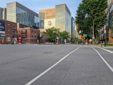 Quebec, Kanada, 05 Temmuz 2025: Sabahın erken saatlerinde modern binalar ve yeşil ağaçlarla kesişen şehir
