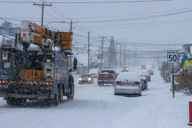 Kanada, 10 Kasım 2025: Kamyon ve arabalar yoğun kar fırtınası sırasında karlı şehir caddesinde yol alıyorlar