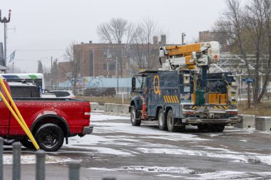 Kanada, 07 Kasım 2025: Kamyon ve kırmızı kamyonet karlı caddede binaların yakınına park edildi