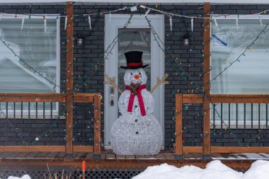 Kanada, 13 Kasım 2025: Kırmızı eşarp ve şapkalı kardan adam ziyaretçileri kapıda karşıladı
