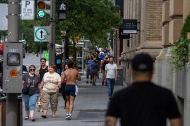 Quebec, Kanada, 05 Temmuz 2025: Yaya, ağaç, tabela ve binalarla dolu yoğun şehir kaldırımı.