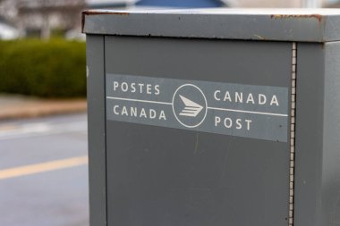 Kanada, 04 Kasım 2025: Kanada Posta Kutusu İki dilli etiketli bir şehir caddesinde