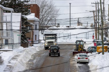 Kanada, Quebec, 17 Kasım 2025: Kar şehir caddesini araçlar, sabanlar, elektrik hatları ve kış sahneleriyle kapladı