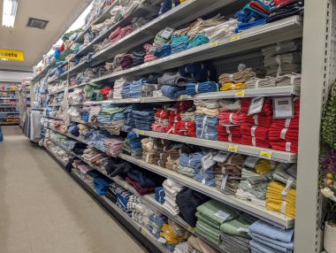 Kanada, Quebec, 22 Kasım 2025: Renkli banyo havluları perakende mağaza koridorunda raflarda düzgünce istiflendi