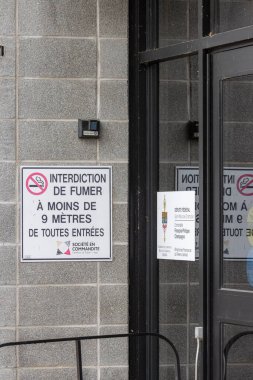 Kanada, Quebec, 27 Kasım 2025: Gri tuğla bina giriş kapısı dışında sigara içilmiyor