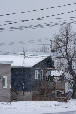 Kanada, Quebec, 30 Kasım 2025: Kar evlere, elektrik hatlarına ve çıplak ağaçlara sessizce yağıyor.