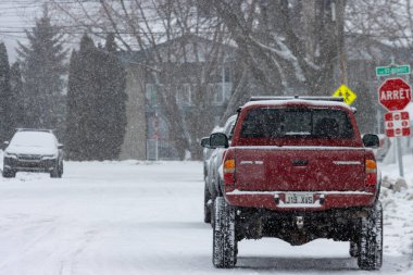 Kanada, Quebec, 30 Kasım 2025: Karlı yolda kırmızı kamyon dur işareti ve kar yağıyor