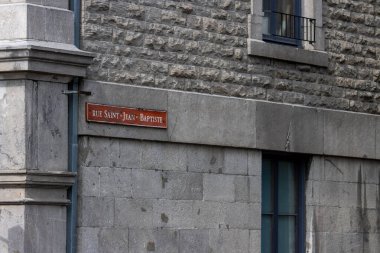 Kanada, Quebec, 05 Temmuz 2025: Kızıl Fransız sokak tabelası eski taş bina duvarına asıldı