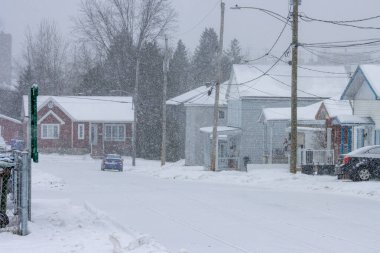 Kanada, Quebec, 30 Kasım 2025: Kar banliyö caddesini evler, arabalar, ağaçlar, elektrik direkleriyle kapladı