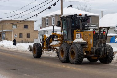 Kanada, Quebec, 18 Kasım 2025: İkametgah caddesinde kar temizleyen büyük sarı yol çizicisi