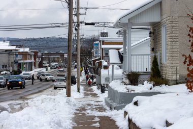 Kanada, Quebec, 13 Kasım 2025: Mahalleyi, işlek caddeyi, yayaları, araçları, evleri, kış atmosferini kar kapladı.