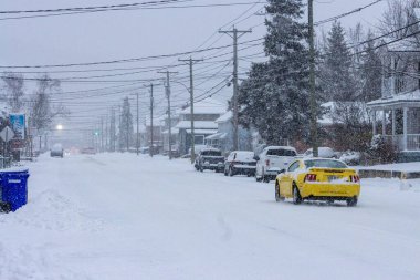 Kanada, Quebec, 10 Kasım 2025: Sarı spor araba karla kaplı banliyö sokak manzarası