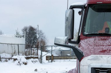 Kanada, Quebec, 13 Kasım 2025: Soğuk kış sabahı karlı çitlerin yanına park edilmiş kırmızı kamyon