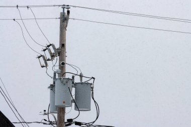 Kanada, Quebec, 30 Kasım 2025: Kar trafolar ile yalnız bir elektrik direğine yavaşça düşüyor