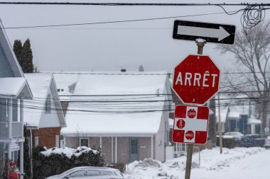 Kanada, Quebec, 30 Kasım 2025: Karlı çatılara Fransız dur levhalarıyla kar yağıyor.