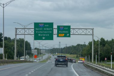 Kanada, Quebec, 20 Temmuz 2025: Bulutlu gökyüzü altında arabaları Quebec 'e götüren ıslak otoyol sahnesi