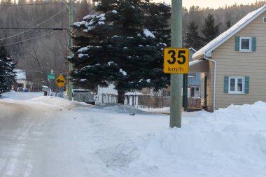 Kanada, Quebec, 05 Aralık 2025: Kar, hız sınırı levhası görünen sakin yerleşim yerlerini kapladı