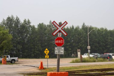 Kanada, Quebec, 25 Temmuz 2025: Fransız demiryolu kavşağı dur işareti kamyon park ağaçları bulutlu gökyüzü
