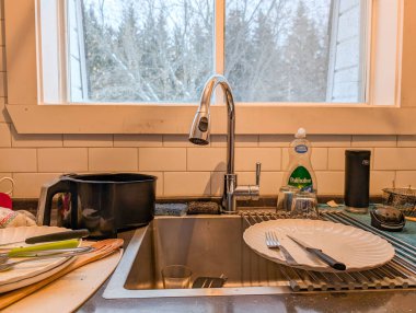 Kanada, Quebec, 23 Kasım 2025: Kahvaltı yaptıktan sonra mutfak lavabosunda bırakılan tabaklar ve çatallar