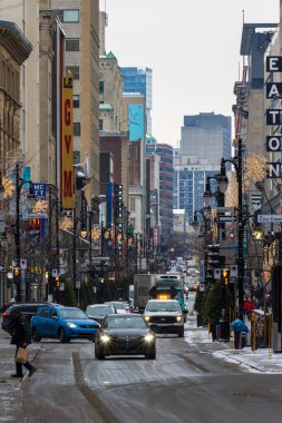 Kanada, Montreal, 23 Aralık 2025: Arabalar yayalar ve trafik ışıklarıyla dolu kış kenti caddesi