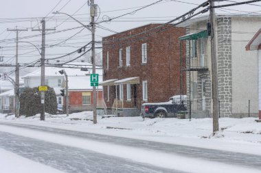 Kanada, Quebec, 30 Kasım 2025: Hastane tabelası, elektrik hatları, tuğla ve taş binaları olan karlı cadde