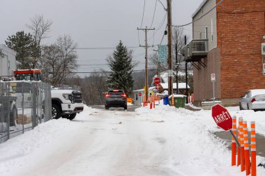 Kanada, Quebec, 10 Kasım 2025: Kar, inşaat, araçlar, dur işaretleri ve görünür engellerle kaplı cadde