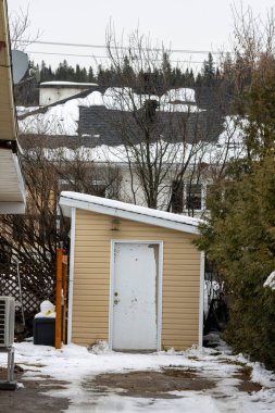 Kanada, Quebec, 27 Kasım 2025: Kışın tek başına beyaz kapılı küçük sarı kulübe