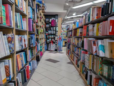 Kanada, Montreal, 22 Aralık 2025: Dar kitapçı koridorunda renkli kitaplıklar, canlı edebiyat cenneti.