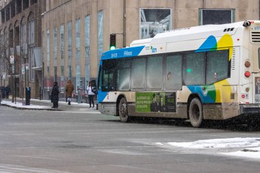 Kanada, Montreal, 23 Aralık 2025: Karlı kış gününde otobüsle şehir caddesi sahnesi
