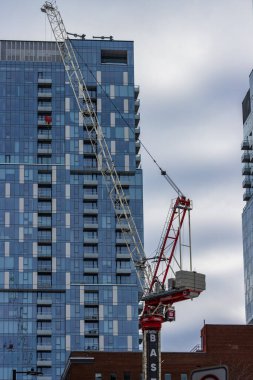 Kanada, Montreal, 25 Aralık 2025: İnşaat vinç kaldırma malzemeleri uzun cam bina cephesi