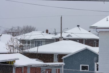 Kanada, Quebec, 30 Kasım 2025: Kar yağışlı kış sırasında çatıları ve sakin banliyö mahallelerini kapladı