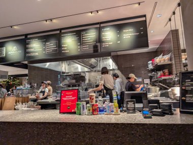 Kanada, Montreal, 22 Aralık 2025: Personel siparişleri ve görünür menülerle dolu hareketli restoran mutfağı