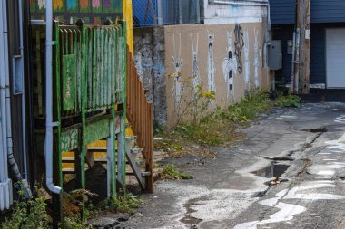 Kanada, Quebec, 08 Kasım 2025: Yeşil merdivenler, renkli duvar resimleri, çatlak sokakların yanında boyanmış karakterler