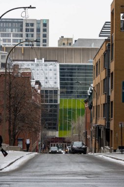 Kanada, Montreal, 23 Aralık 2025: Modern mimari ve park halindeki arabalarla şehir sokak sahnesi.