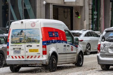 Kanada, Montreal, 24 Aralık 2025: Karlı şehir caddesinde ilerleyen Kanada Posta Minibüsü.