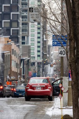 Kanada, Montreal, 23 Aralık 2025: Kışın şehir sokağı, trafik ve yüksek binalar, soğuk hava.